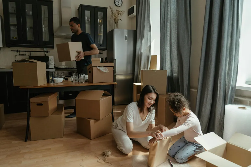 A child helps his parents unpack moving boxes in their new home.