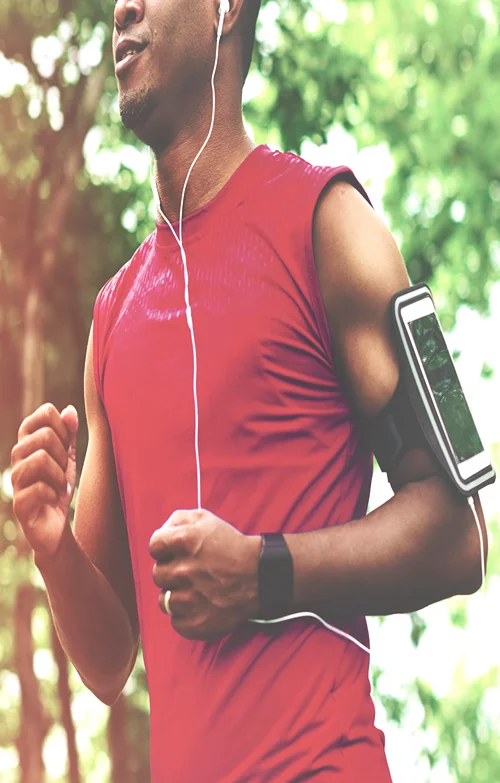 A man jogging with a smartphone strapped to his arm.