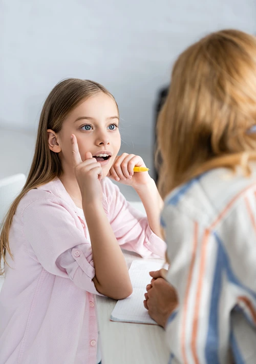 A young girl is engaged in conversation with her mom.