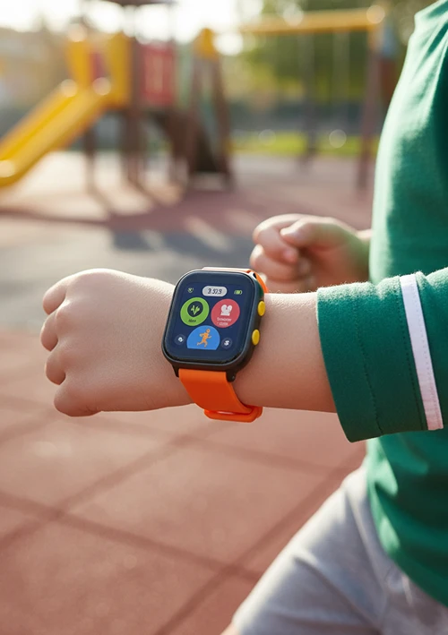 A child runs outside in playground sporting a smartwatch.