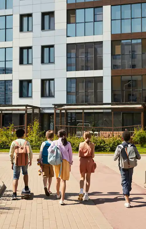 A group of students wearing backpacks while walking to school.