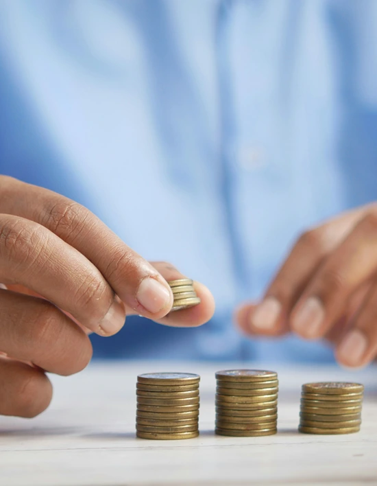 A closeup of holding coins as he count them on a stack.
