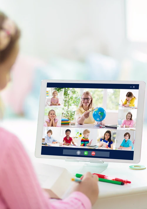 A girl sits in front of a computer as part of online school.