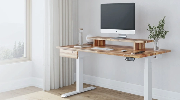 Ergonomic desk in corner by a window.