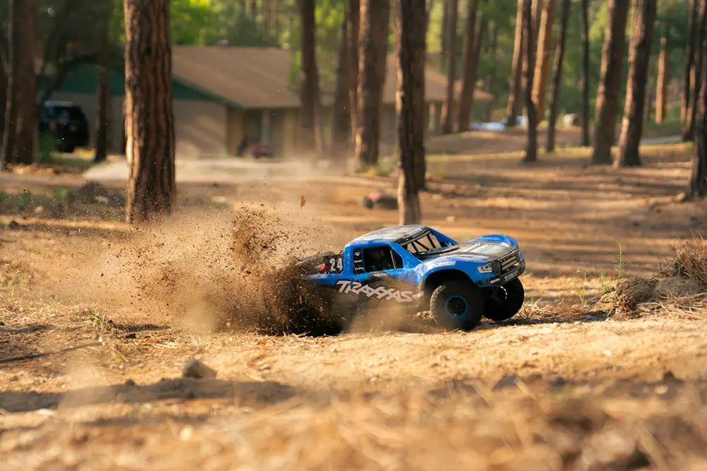 A remote control truck peels out in dirt