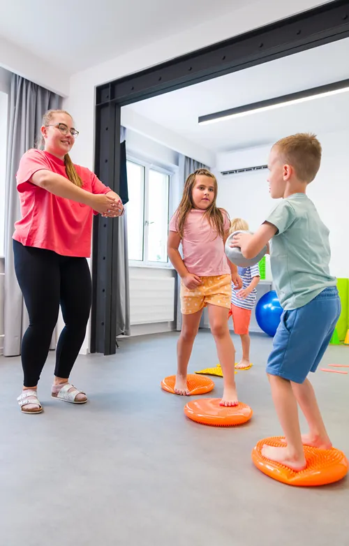 An occupational therapist is working with a girl and a boy.