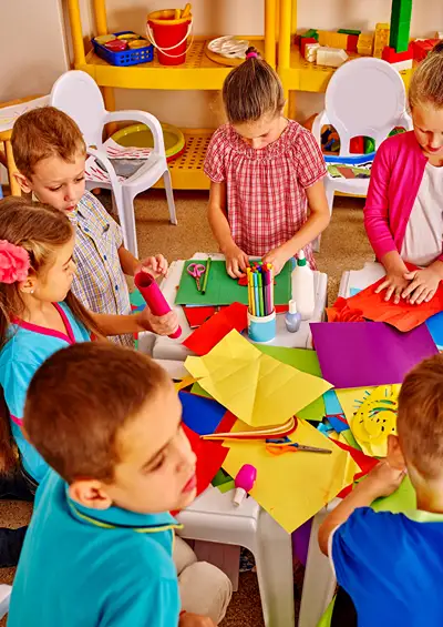 A group of kindergarten boys and girls working around a table