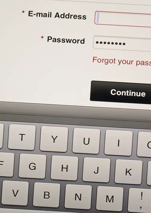 An email login and password box is shown on screen above a keyboard.