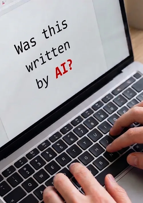 A male types these words a laptop: "What this written by AI?"
