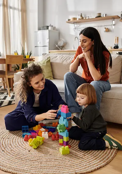 Child playing on floor in living room at home as parents watch.