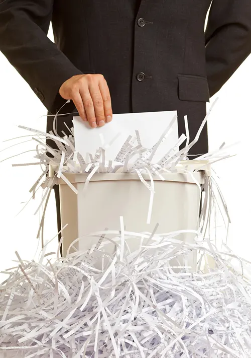 Man in dark suit shredding paper.