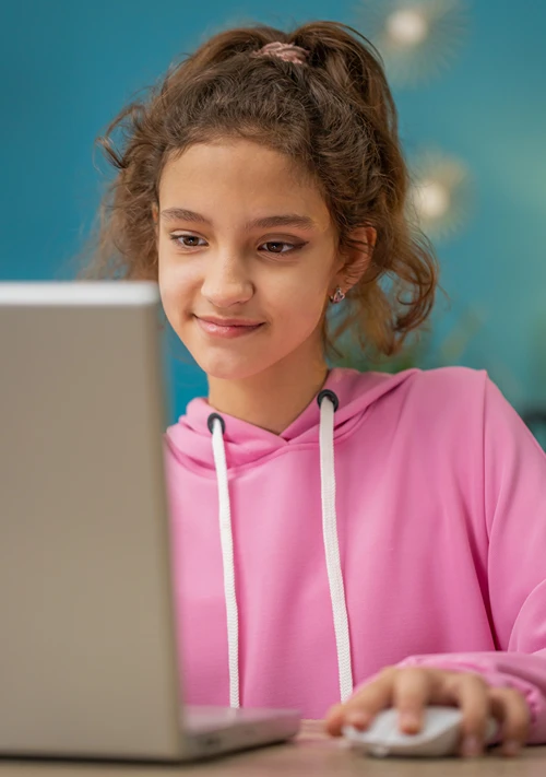 A female middle age student uses a mouse on a laptop.