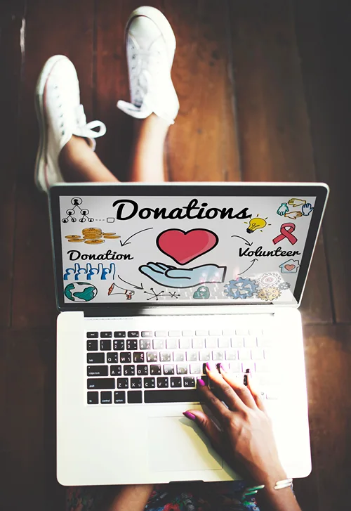 Artist writing on laptop: "Donations" with a drawing of a red heart.