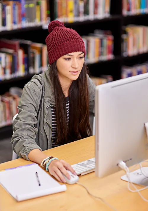 A female student works on a lap top in the library.