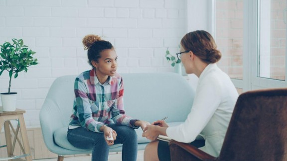 A teen girl having stern conversation with a female therapist.