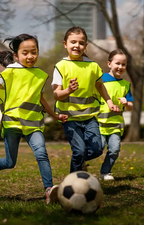 A group of kids playing soccer outdoors.