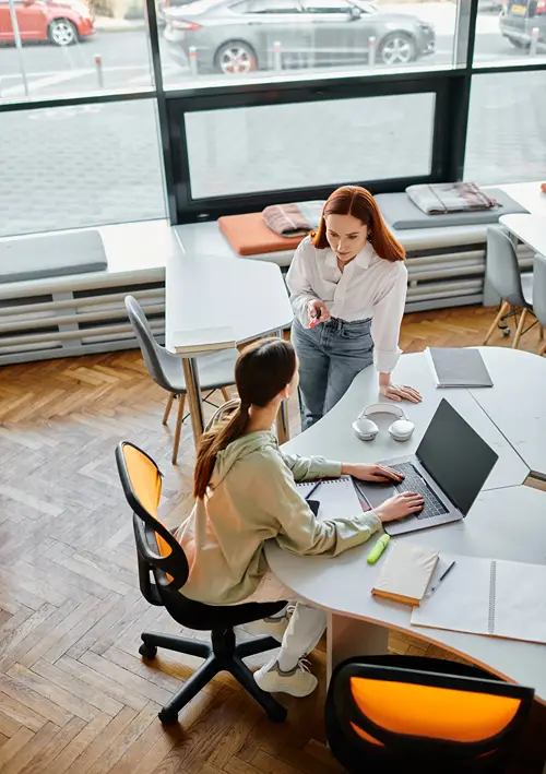 A view from above of two women working in a school administration office.