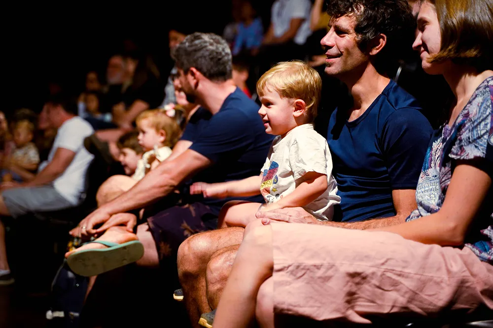 Parents with kids enjoying a theater production.