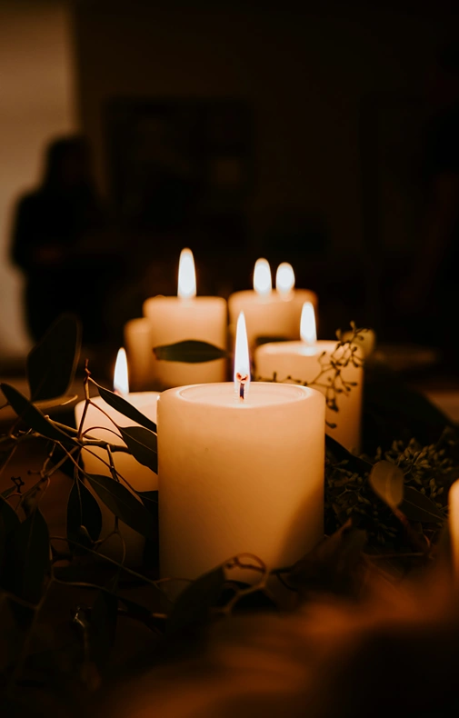 A group of candles arranged and decorated on a table.